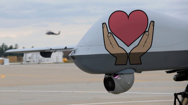 a drone on a landing strip with a picture of a heart in someone's hands