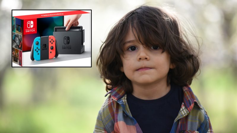 Young boy with tan skin, brown eyes and long brown hair against a blurred nature backround with a Nintendo Switch beside him in a separate box.