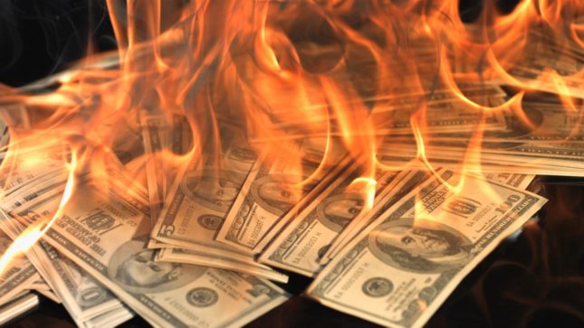 Many 100 dollar bills in flames.
