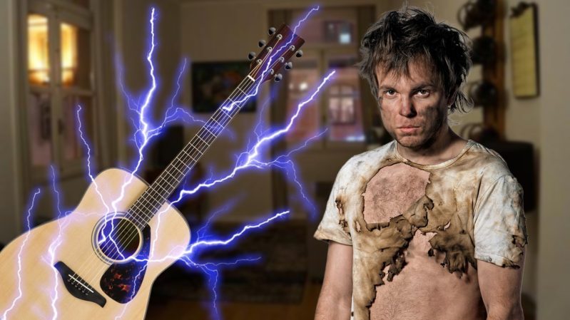 Guitar with shock wave coming out of it and a boy whose shirt is burned.